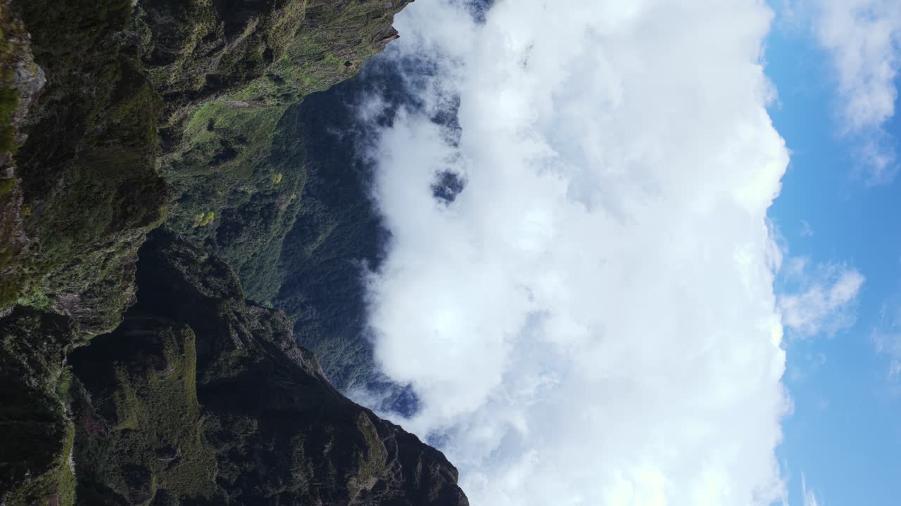 Pico do Arieiro mountains shrouded in clouds, Madeira, Portugal. Aerial drone backward, copy space, vertical format