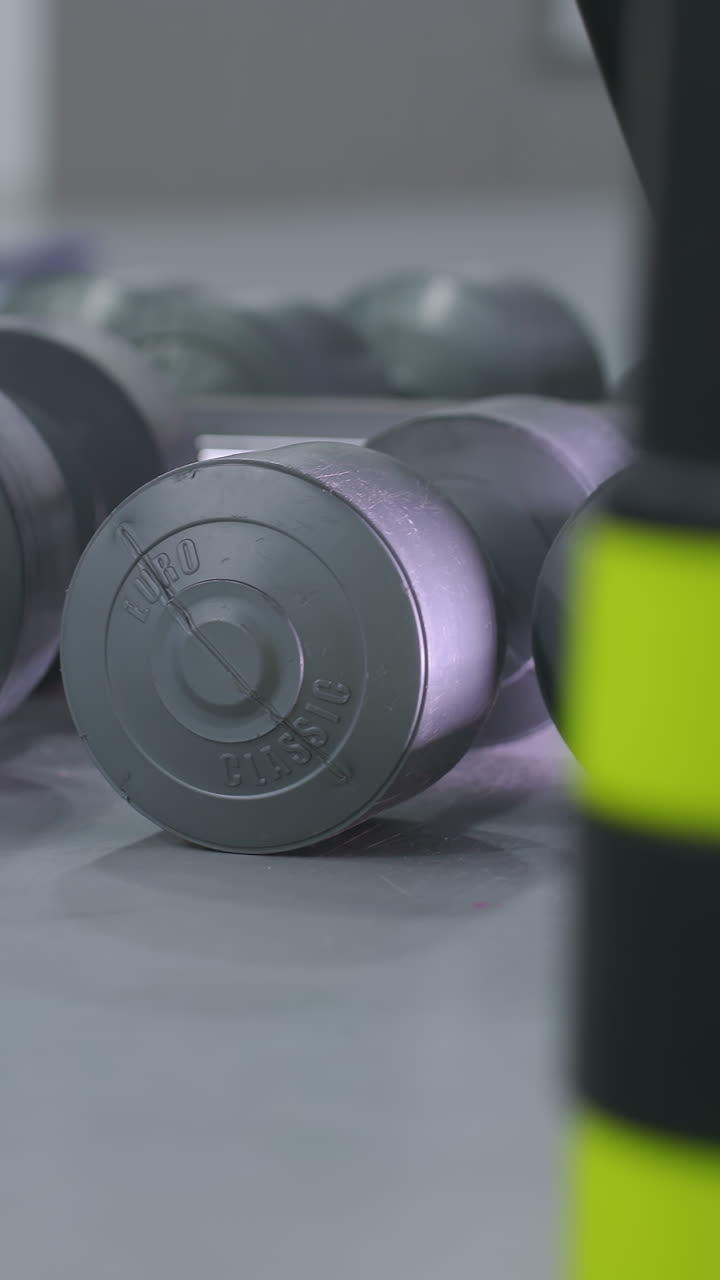 primer plano de múltiples pesas cuidadosamente dispuestas en el suelo del gimnasio, reflejándose en un espejo, la configuración destaca el equipo de entrenamiento de fuerza utilizado para entrenamientos de fitness