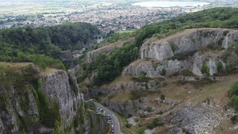 aerial vista of the limestone cliff formations at cheddar gorge in the mendip hills, somerset, with the village of cheddar in the background
