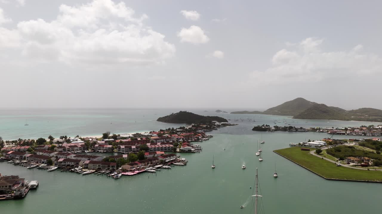 Jolly Harbor aerial view showing boats, turquoise waters, and coastal town on a sunny day