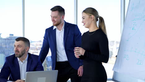 business discussion. group of confident business people in formal wear sitting at the table together and discussing something while looking at the laptop