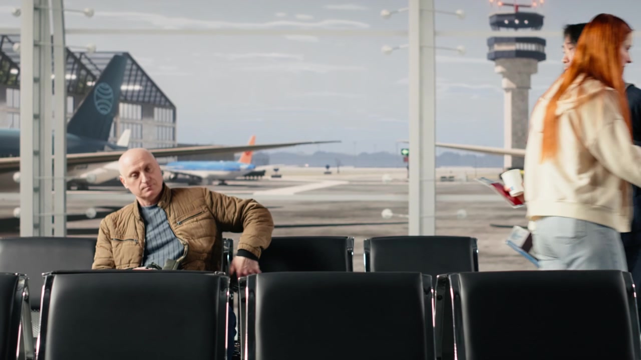 Reisende på en travel flyplass som reiser seg fra stoler for å gå til ombordstigningsgaten