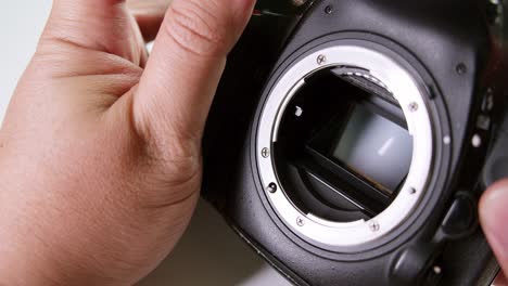 close-up of a technician clicking the shutter and meticulously checking the sensor of a dslr camera