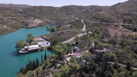 aerial view orbiting waterfront properties along green lake in the valley of the taurus mountains in turkey