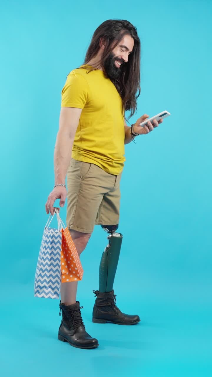 Uomo con protesi alla gamba che tiene borse della spesa e usa il telefono