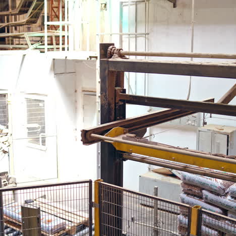 industrial robot arm at a modern factory. manufacturing production. advanced robotic machine loading packed bags. innovative technologies indoors.