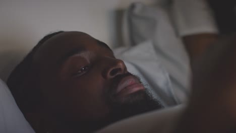 Close-Up-Of-Couple-At-Home-At-Night-Both-Looking-At-Their-Mobile-Phones-In-Bed-1