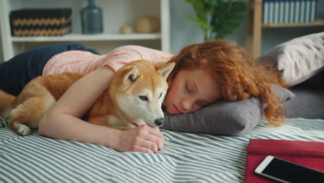 woman and dog sleeping together on a bed