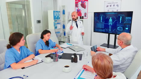 Medical-physician-explaining-treatment-pointing-at-digital-monitor