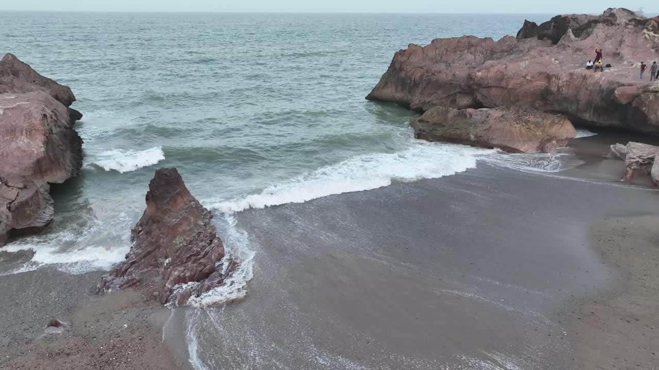 воздушный дрон вращается над красивыми волнами, разбивающимися на скалистых пляжах гадани, пакистан в вечернее время