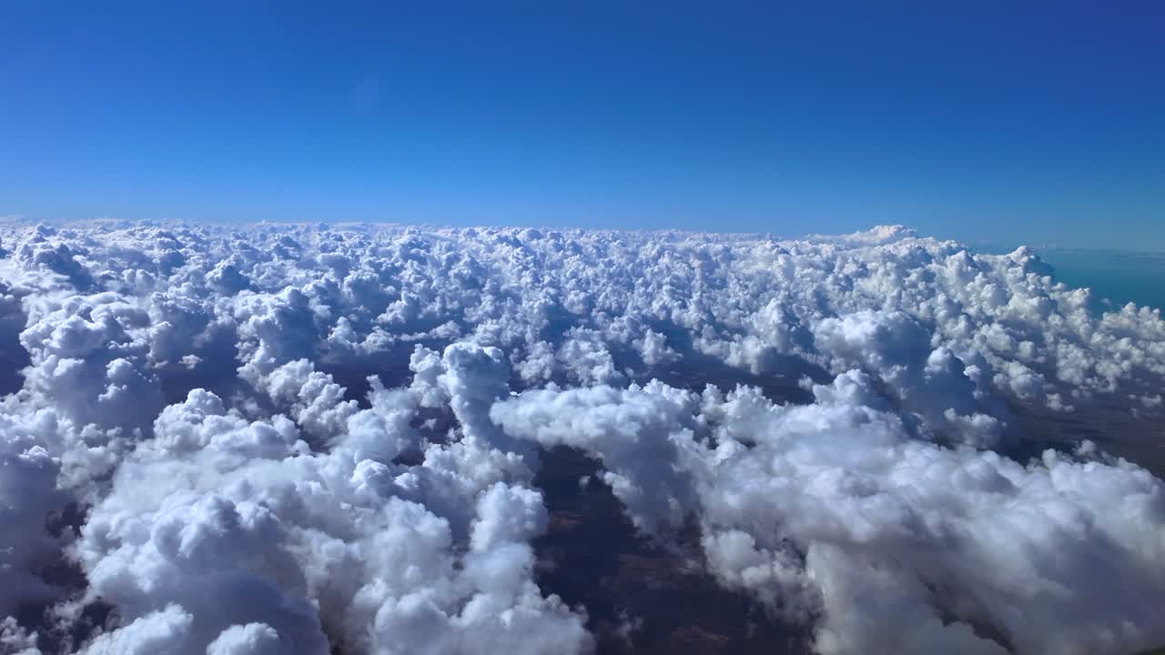 Cockpit View Taken From an Airplane Cockpit While Flying Over an Endless Sea of Cottony Clouds Under a Deep Blue Sky. Over a Flat Coastal Landscape