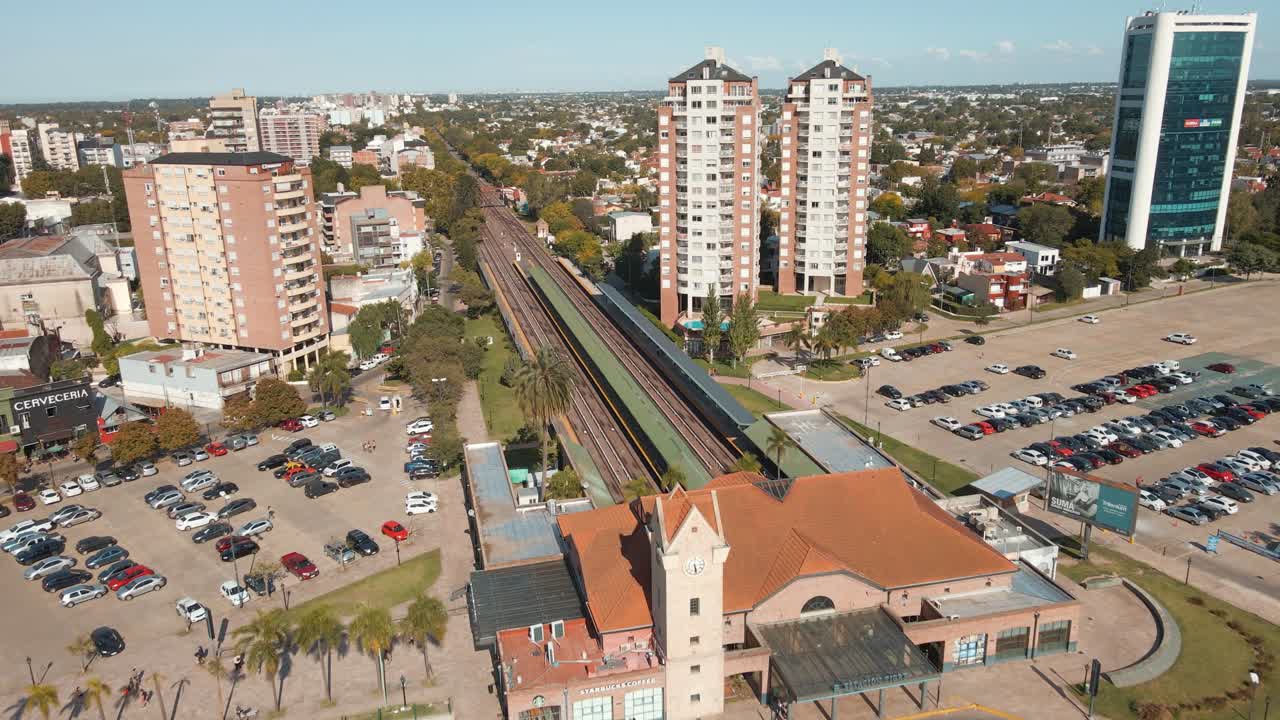 toma aérea de establecimiento de la estación de tren tigre volando sobre el edificio y las vías.