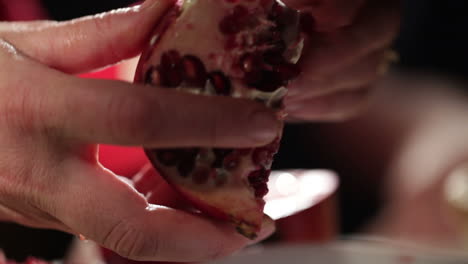 Woman-hands-removes-seeds-from-the-pomegranate