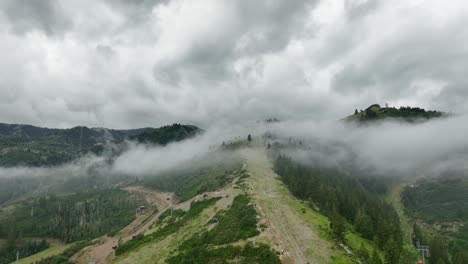 aerial of low fog hanging over mountain and forest trees-11