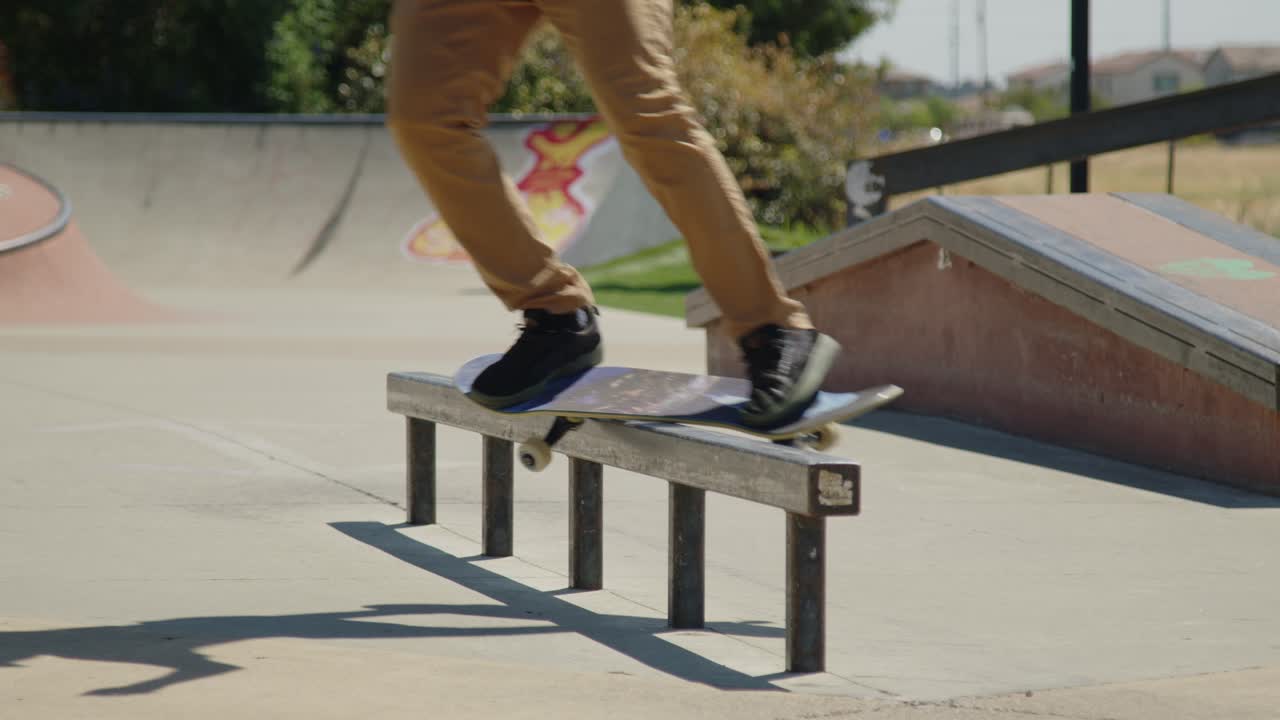 Dynamic shot of a skateboarder grinding on a metal rail at the skatepark