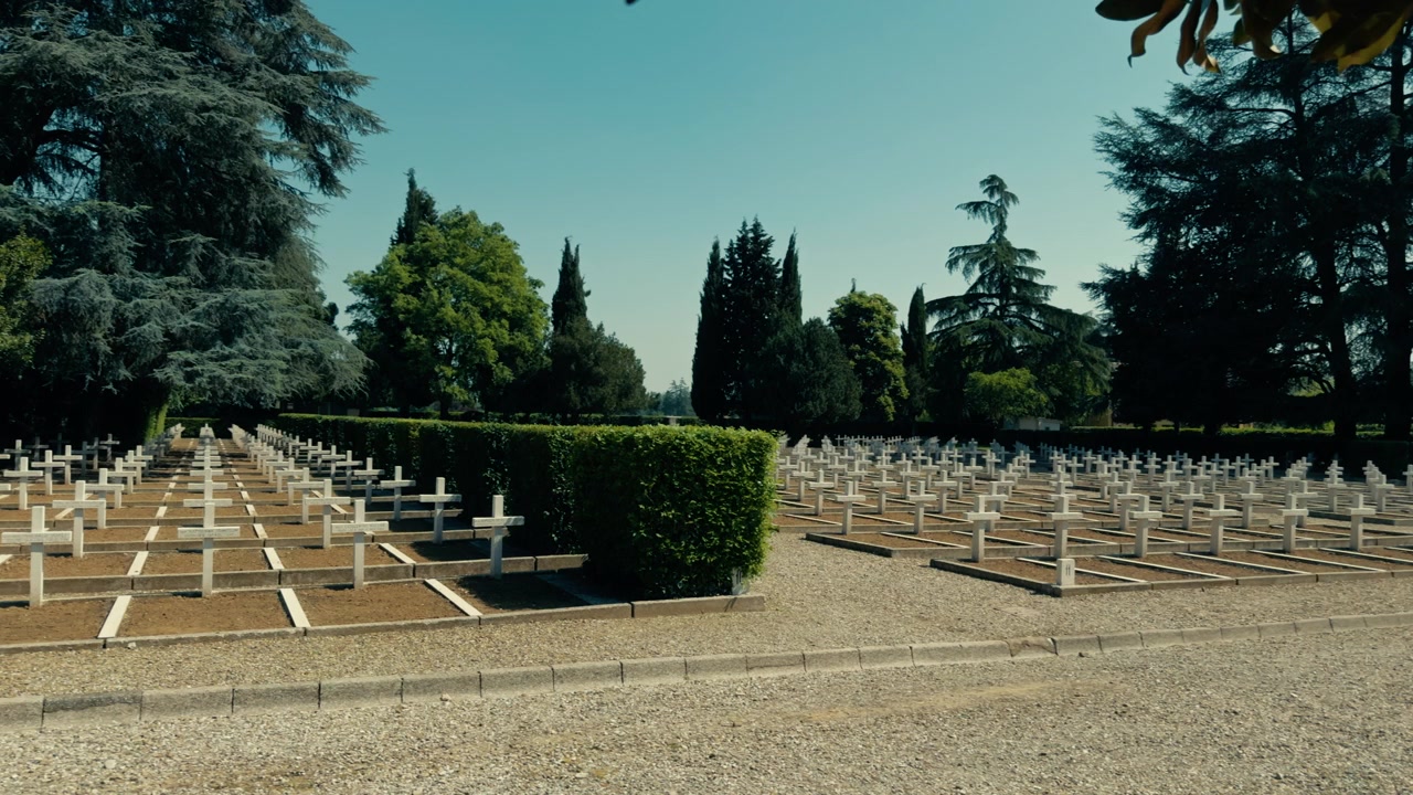 Paesaggio di cimitero militare con croci bianche e cielo azzurro