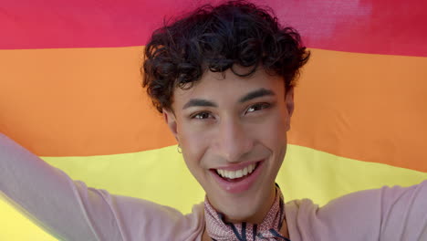 smiling person holding rainbow flag, celebrating lgbtq+ pride and identity
