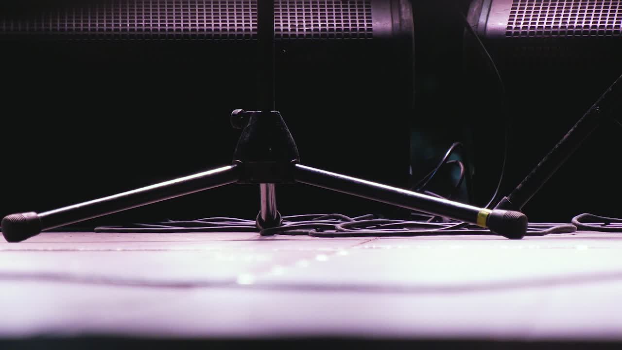 disparo de cerca de los zapatos de la persona de pie frente al micrófono saliendo después de una noche de rock en vivo