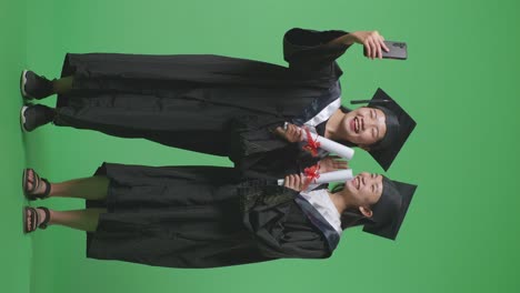 dos graduados tomando una selfie