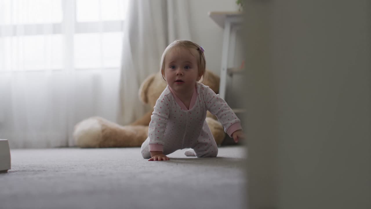 bebé caucásico arrastrándose por el suelo en casa