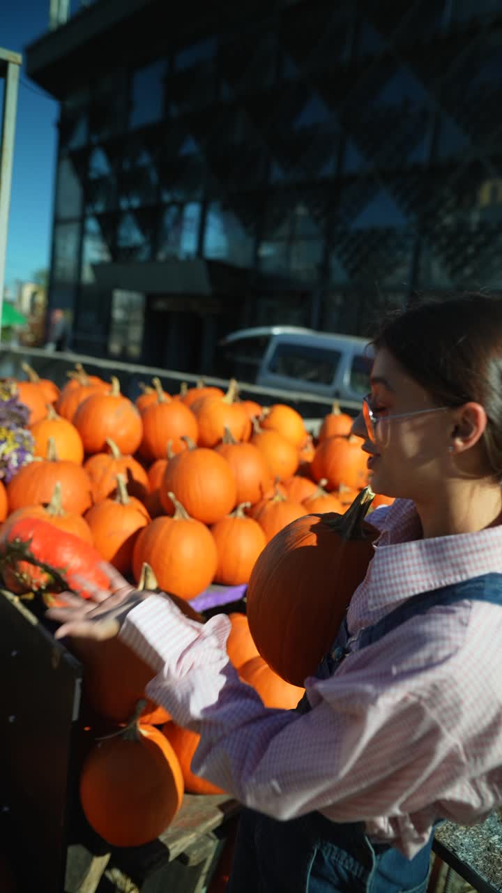 mujer sosteniendo una calabaza en el mercado de un granjero