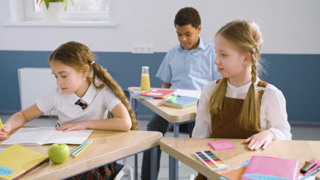 two female students sitting at desk in english classroom 1