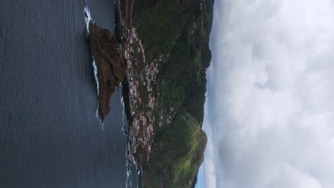 aerial view of porto moniz, houses, volcanic islet and coastline in madeira island, portugal. vertical video