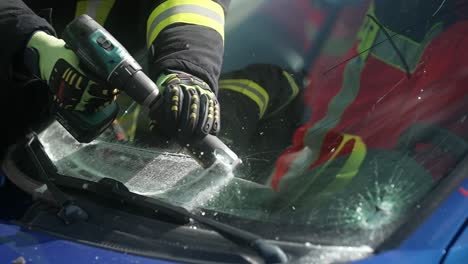 cutting windshield during rescue operation of firefighters after a car accident in slow motion