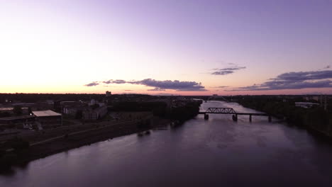 Toma-Aérea-De-La-Hora-Mágica-De-Un-Puente-De-Tren-En-El-Río-Mississippi