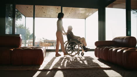 caregiver assisting senior in wheelchair at home