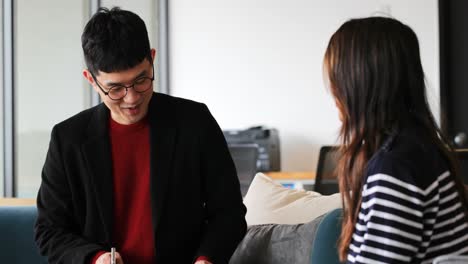 Young-Asian-business-colleagues-interacting-with-each-other-in-modern-office-4k