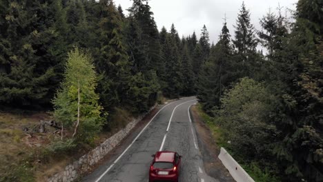 Car-Traveling-Through-Mountain-Road-On-A-Cloudy-Day---drone-shot