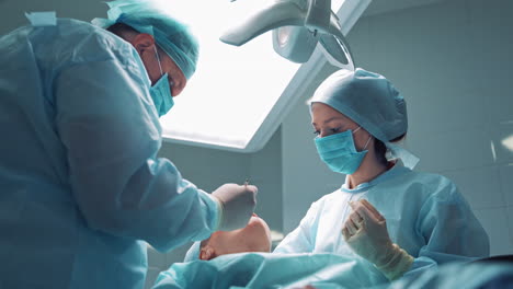 assistant woman and stomatologist man in medical masks treating client's teeth. orthodontist works with an assistant in a modern dental office.