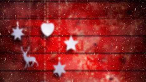 Animation-of-christmas-decorations-with-snow-falling-on-red-boards