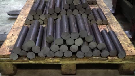 forklifts moving steel round shafts for industrial production.