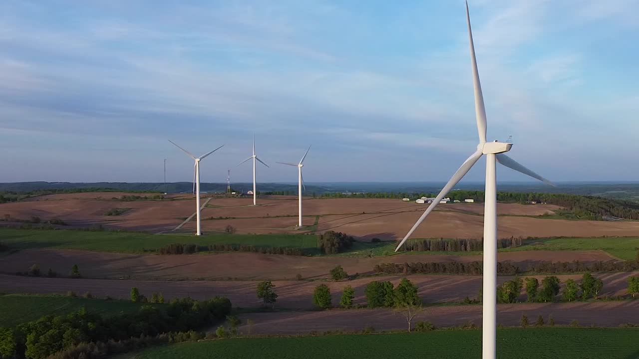 Aerial of renewable sustainable energy wind turbine farms on fields