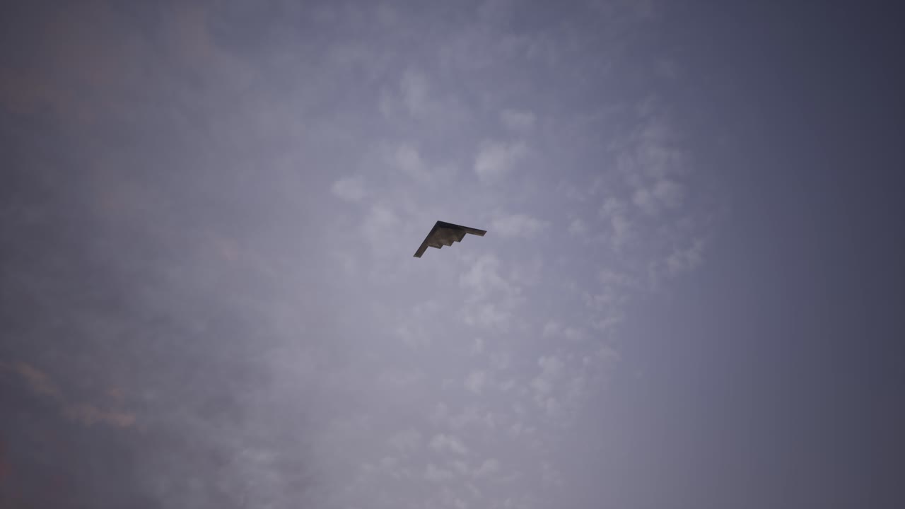 夕焼け空を飛ぶステルス爆撃機
