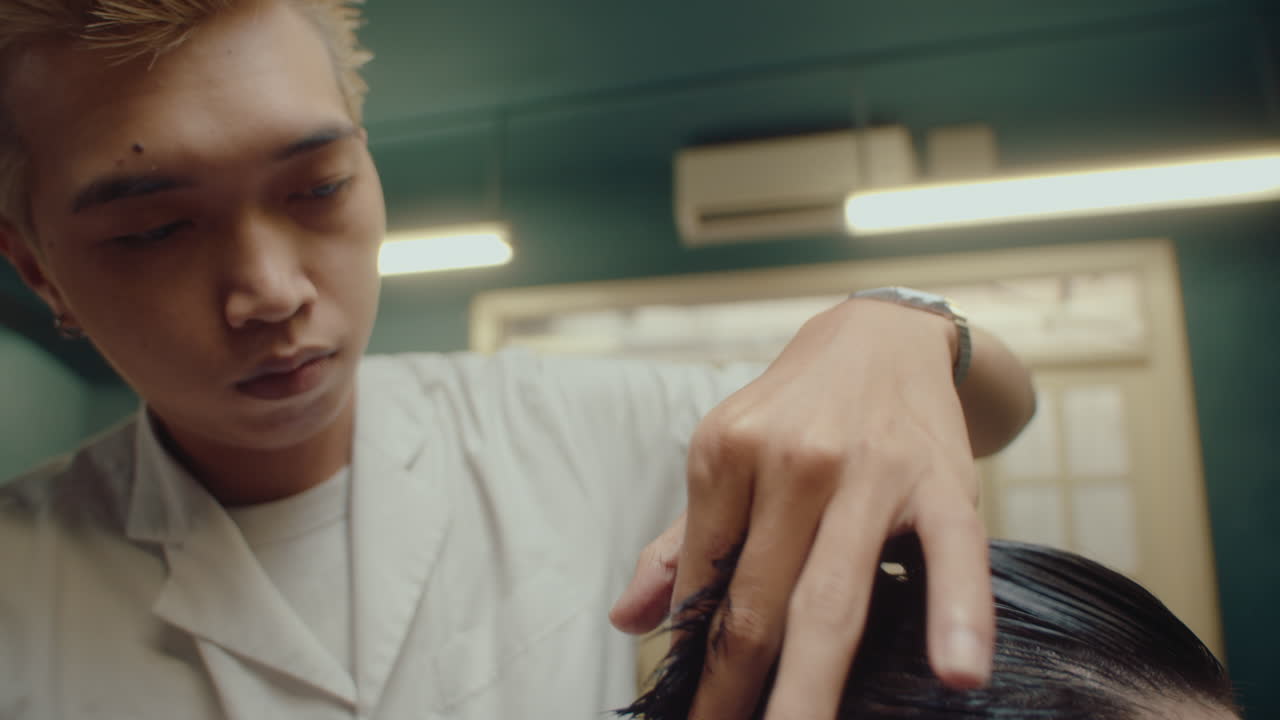 Asian Barber Working with Client in Hairdressing Salon