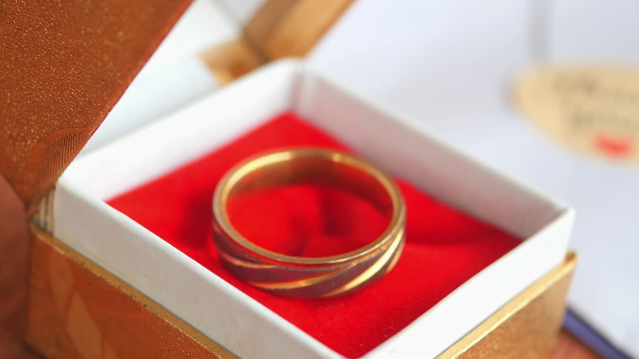 A gold wedding ring in a box
