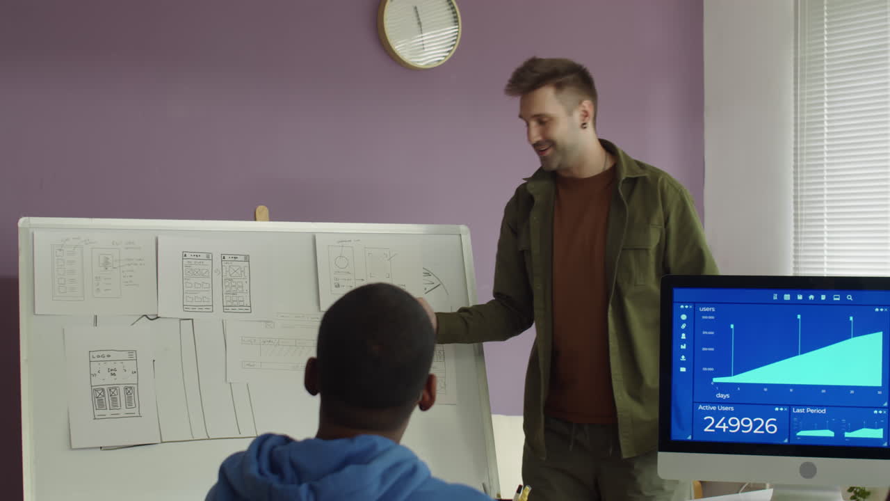 Software Engineer Explaining Work to Newcomers at Office