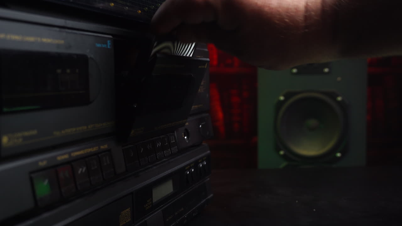 Audiocassetta che si ferma ed espelle il nastro con un altoparlante sullo sfondo.