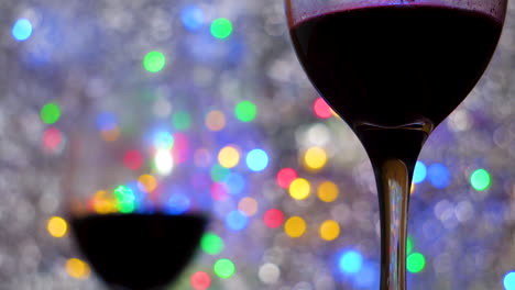 primer plano de vino tinto en copas sobre un colorido bokeh y una manta plateada de cerca en un ambiente íntimo y romántico