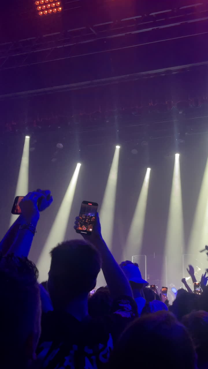 Penonton konser menikmati musik langsung dengan panggung yang terang benderang dan suasana yang semarak