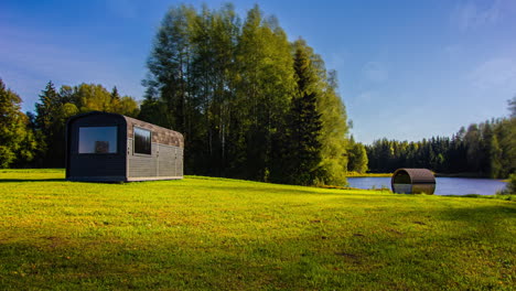 Time-lapse-of-Sunrise-and-Sunset-on-rural-forest-landscape-with-natural-lake,trees-and-wooden-cottage-in-Wilderness---Blue-sky-changing-colors-during-day-to-night-timelapse---5K-Footage