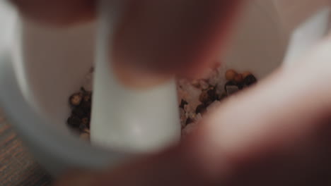 triturar granos de pimienta y sal con mortero y pestillo