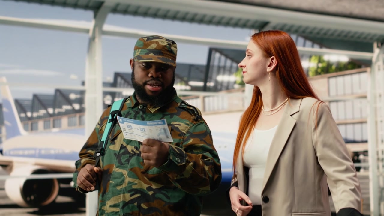Soldado do exército conversando com uma mulher em um terminal de aeroporto moderno