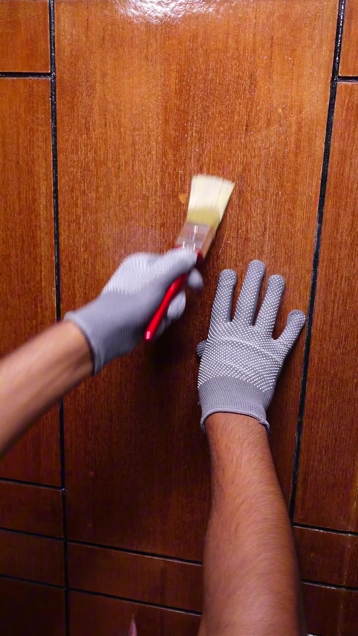Person Applying Varnish to Wooden Surface with Paintbrush