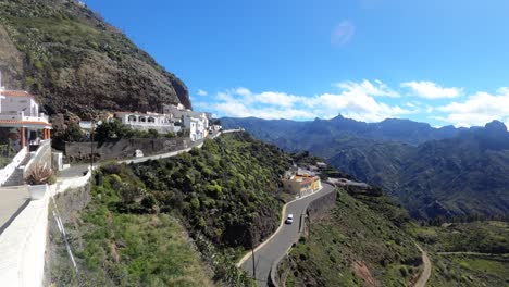 Artenara-town-in-mountains-range-top-time-lapse-with-clouds-and-cars-passing-by-narrow-mountain-road