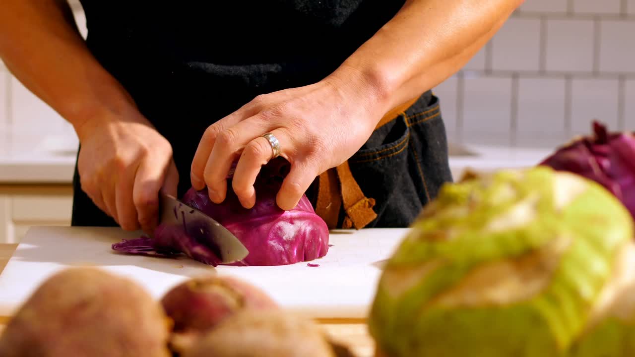Chef cutting purple cabbage in cafe kitchen