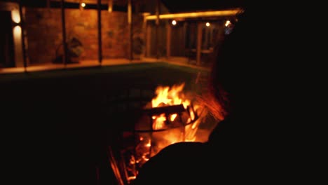 Camera-behind-a-person-at-its-right-side-looking-at-bonfire